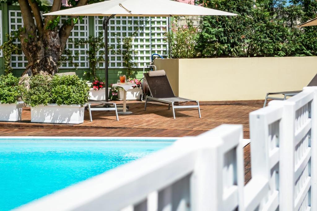 a swimming pool with a chair and an umbrella at Hotel Concorde in Camerano