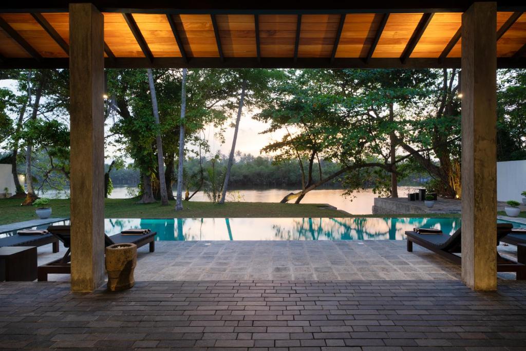 a pavilion with tables and a pool of water at Villa by the River in Ambalangoda-Starflower Villa in Ambalangoda