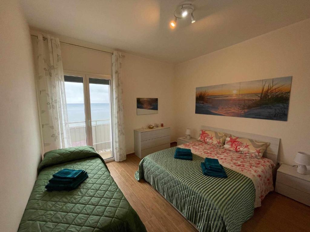 ein Schlafzimmer mit zwei Betten und einem Fenster in der Unterkunft Bellavista in Santa Flavia