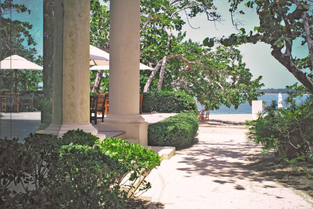 a walkway with chairs and umbrellas on a beach at Casa Colonial Beach & Spa in San Felipe de Puerto Plata