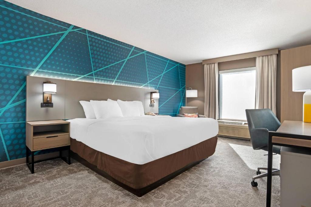 a hotel room with a large bed and a desk at Comfort Inn Livingston in Livingston