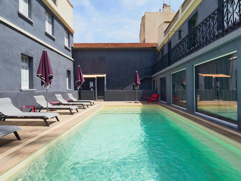 una piscina al lado de un edificio en Kyriad Marseille Blancarde - Timone, en Marsella