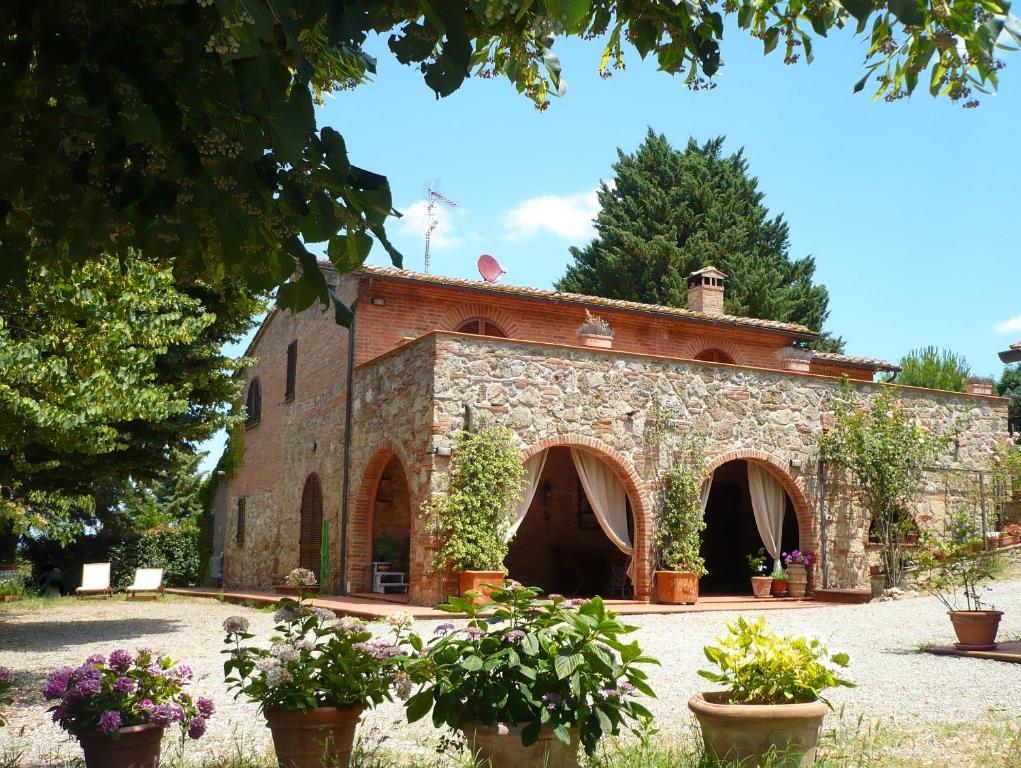an old stone building with potted plants in front of it at Podere Sionne in Chiusi