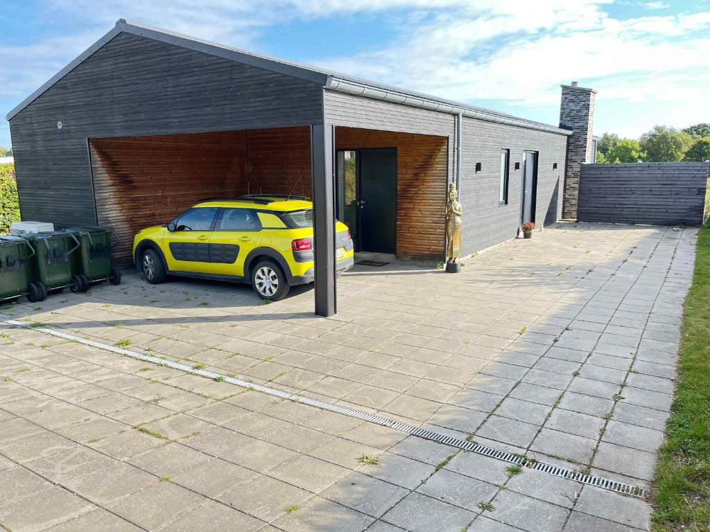 a yellow car parked in front of a garage at Holiday Idyll With Nature And City Nearby in Skødstrup