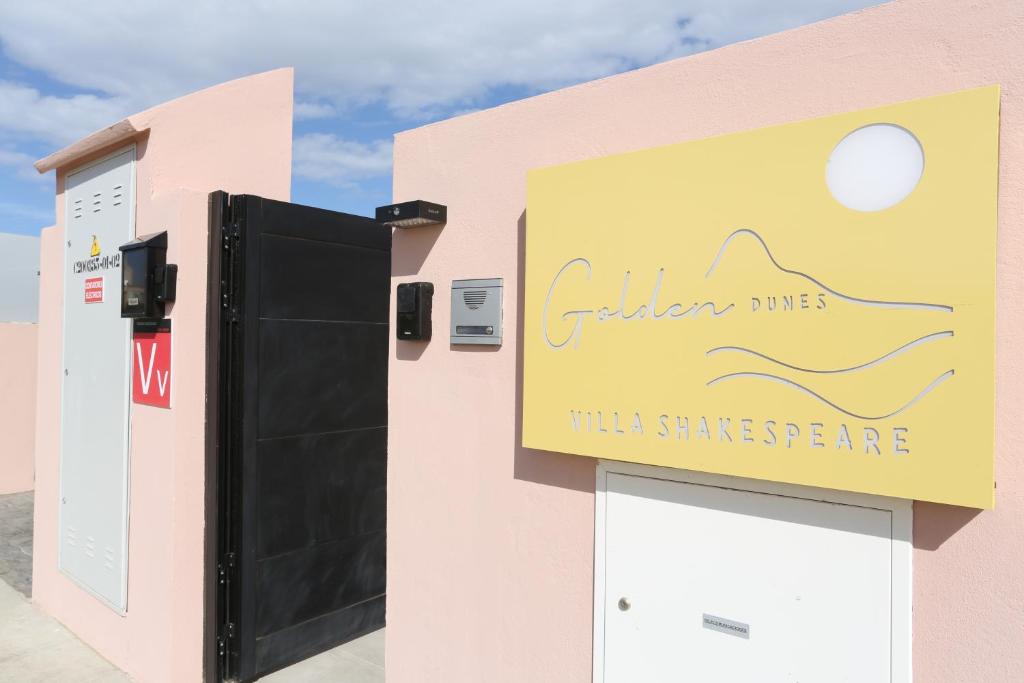 a sign on the side of a building at Golden dunes villa shakespeare in Caleta De Fuste