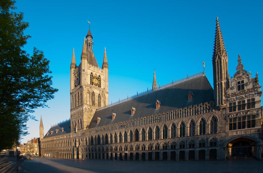 a large building with a clock tower on top of it at Hotel O Ieper in Ieper