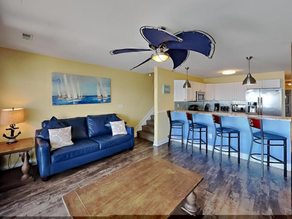 a living room with a blue couch and a kitchen at Put-in-Bay Waterfront Condo #202 in Put-in-Bay