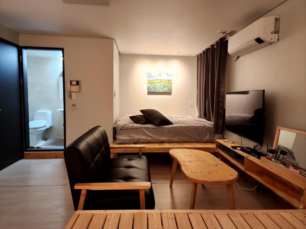 首尔Neovill的一间卧室，配有一张床、一张沙发和一张书桌