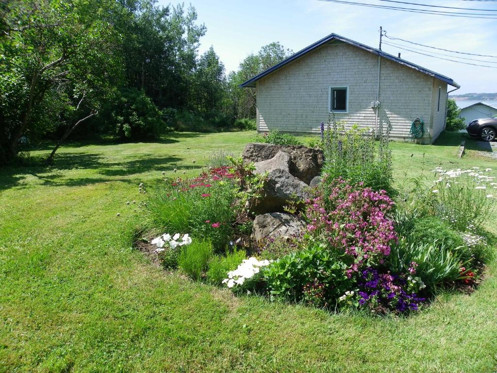 a garden with flowers in front of a house at Haus Treuburg in Port Hood