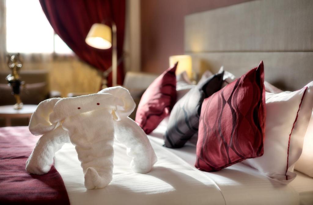 Un elefante disecado sentado en una cama con almohadas en Bravia Hotel Ouagadougou, en Ouagadougou