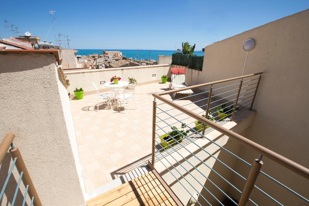 a balcony with a table and a view of the ocean at 4Canti Case Vacanze in Castellammare del Golfo