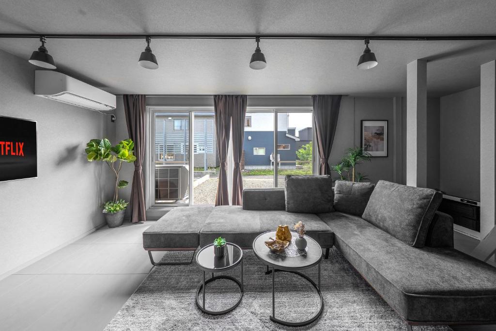a living room with a couch and a table at SnowGarden YIG STAY in Furano
