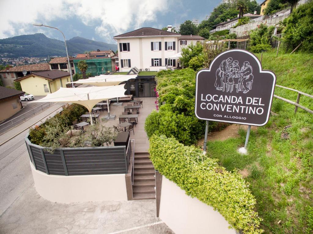ein Schild für ein Restaurant auf einer Straße mit einem Gebäude in der Unterkunft Locanda Del Conventino in Lugano