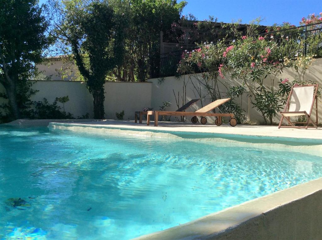 - une piscine avec un banc et une chaise dans l'établissement Villa Mareste, à Grimaud