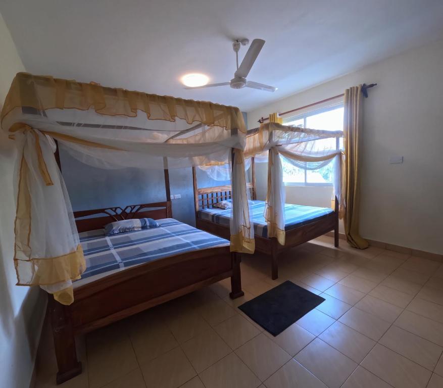 two bunk beds in a room with a window at Haven Homes one bedroom in Diani Beach