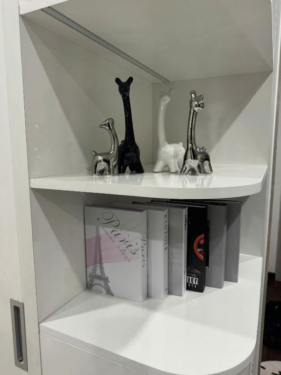 a white shelf with three animals and a book at Mas D3208 in Phú Thú
