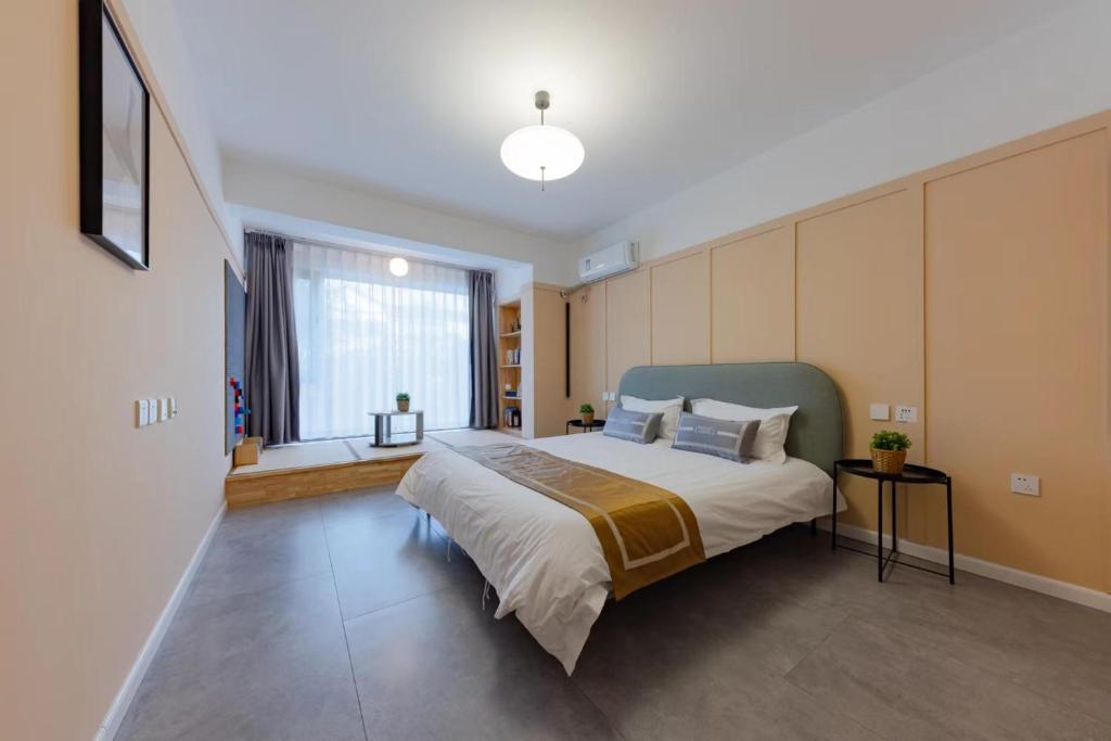 a bedroom with a large bed and a window at Gubei Delin Water Town Boutique Villa (Gubeikou Water Town Scenic Area Branch) in Simataicun