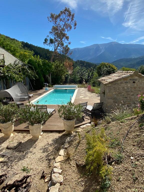 a house with a swimming pool with mountains in the background at LA BAPTISTINE FACE AU VENTOUX la Clue in Plaisians