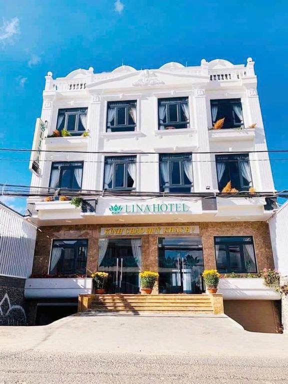 a large white building with stairs in front of it at Lina Hotel in Khu Chi Lăng