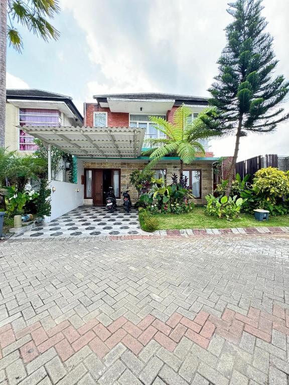 バトゥにあるVilla AHSANの家の前にレンガの私道がある家
