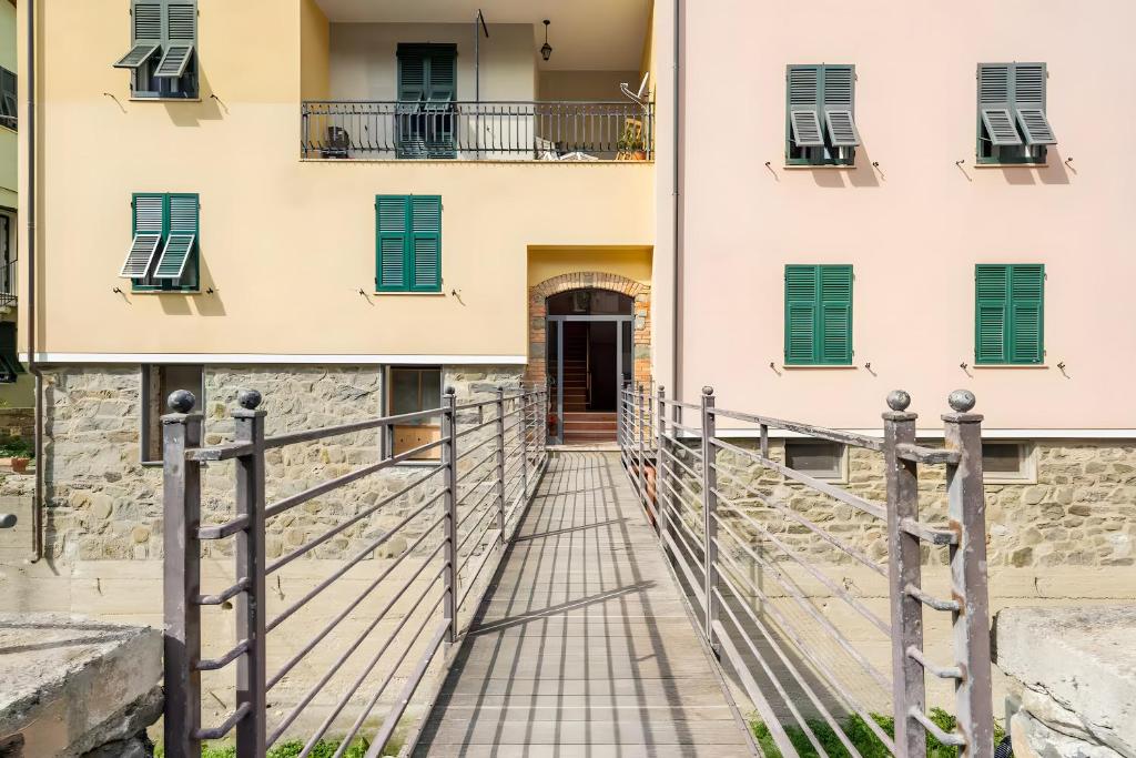 a bridge leading to a building with green shutters at La Rosa Dei Venti in Vernazza