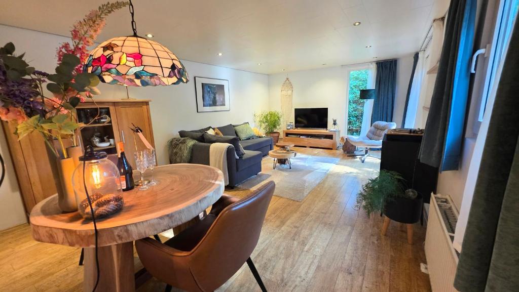 un soggiorno con un tavolo e un divano di Cozy forest cottage in quiet nature reserve a Emst