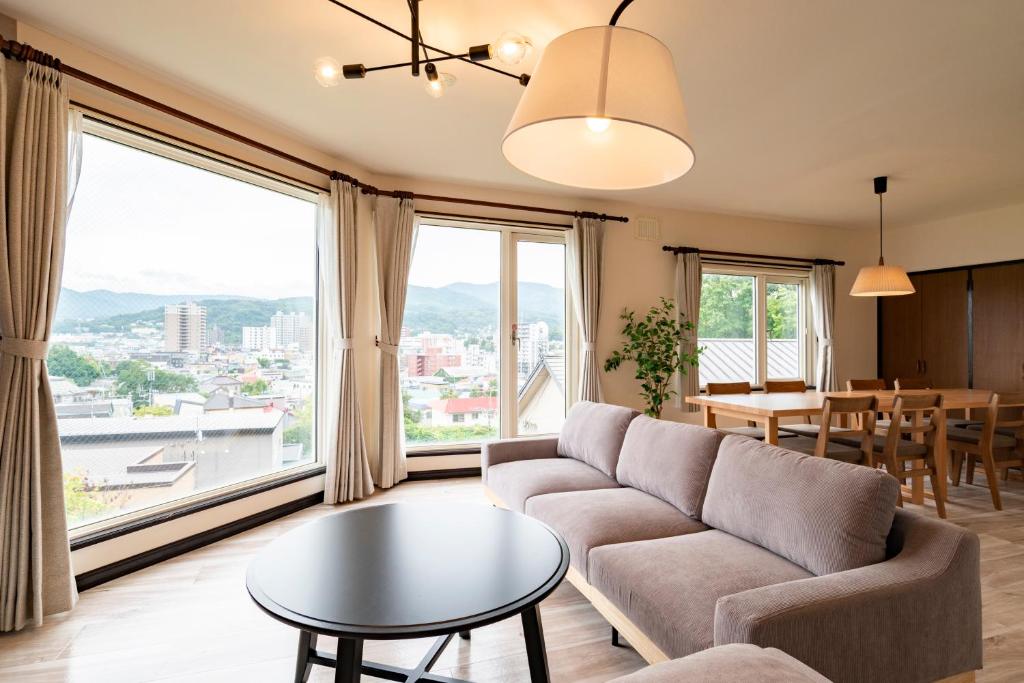 una sala de estar con un sofá y una mesa en Tsubaki オーシャンビュー 観光拠点 閑静な住宅街, en Otaru