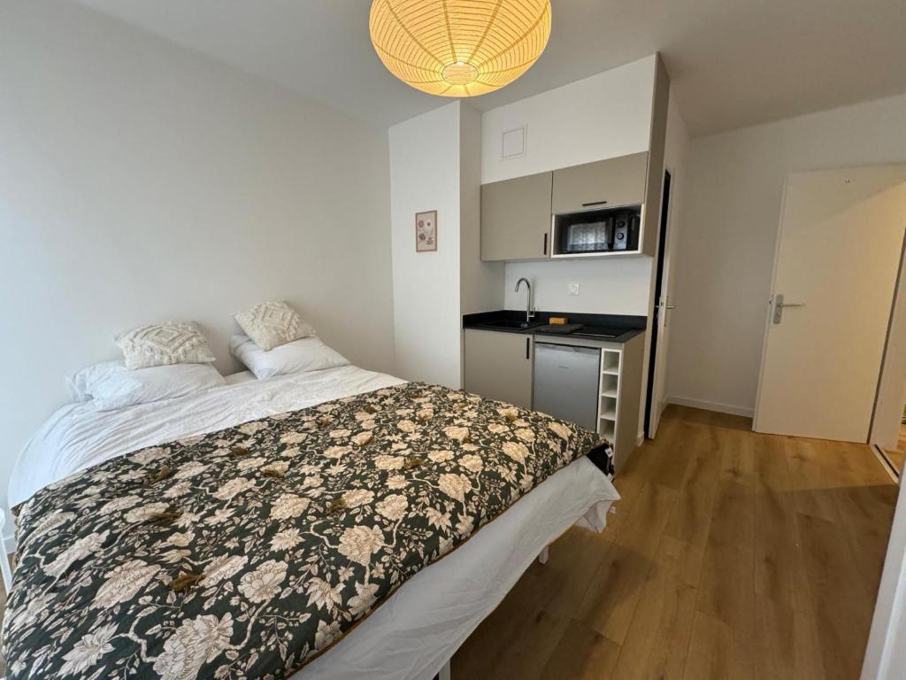 una piccola camera da letto con un letto e una cucina di M093 Marquer Studio à Annemasse avec balcon ad Annemasse