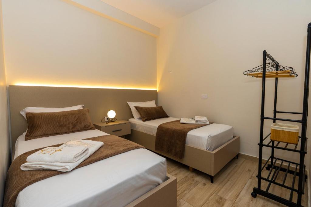 a small room with two beds and a shelf at Class Elite Apartment in Shkodër