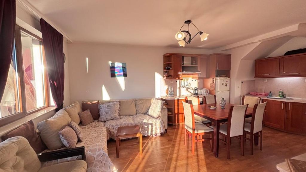 een woonkamer en keuken met een bank en een tafel bij Maisonette on the slope in Manastir 3 in Pamporovo