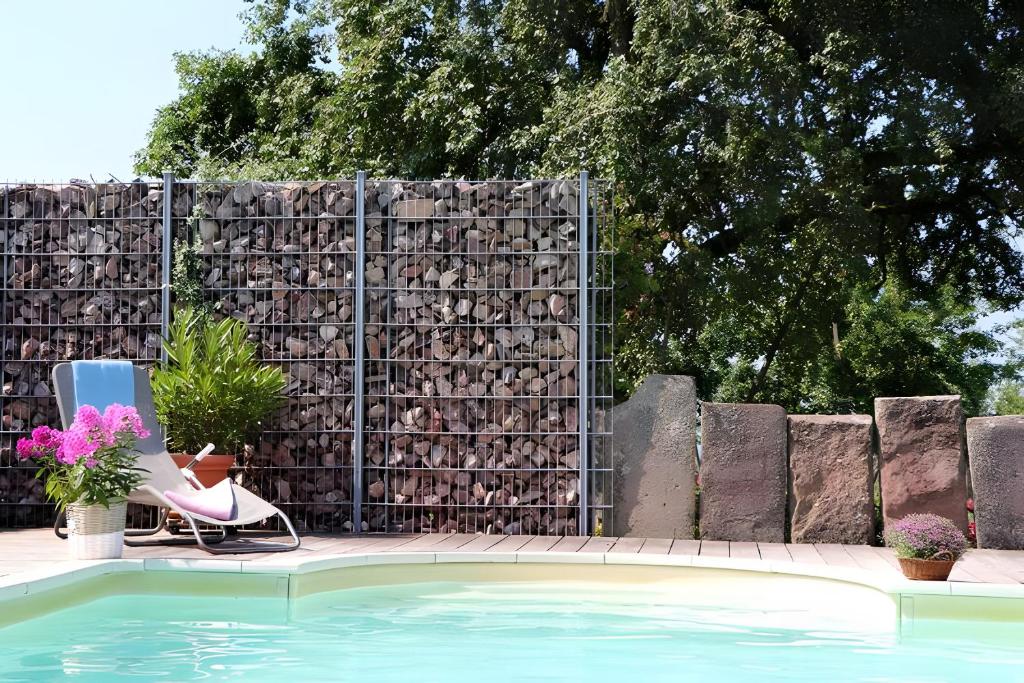a fence next to a swimming pool with a chair and a chair at Ferienhaus Bührer in Freiamt