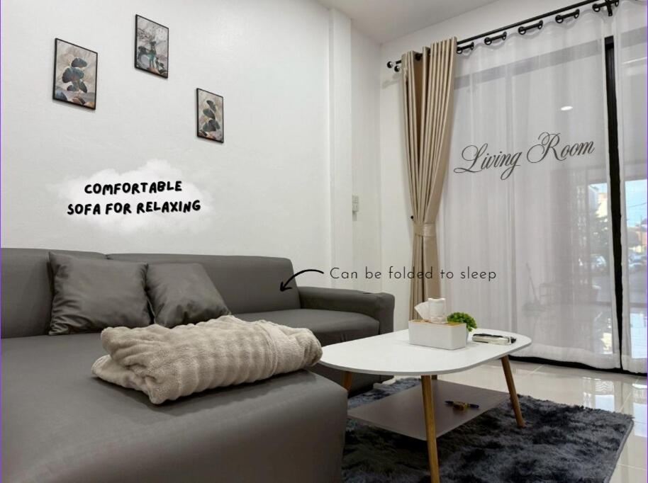 una sala de estar con un sofá y una mesa en O Pha Suk House, en Hat Yai