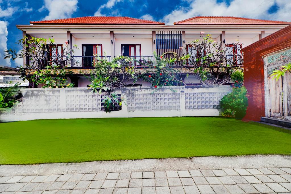 ein Haus mit einem grünen Rasen davor in der Unterkunft Collection O Bali Sanur near Bali Mandara Hospital in Sanur