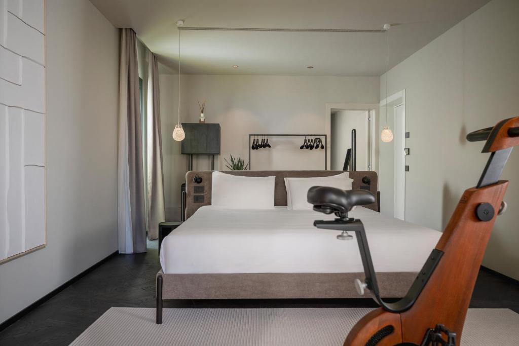 een slaapkamer met een wit bed en een stoel bij Mode Eco Mood Hotel - Adults Friendly in Rimini