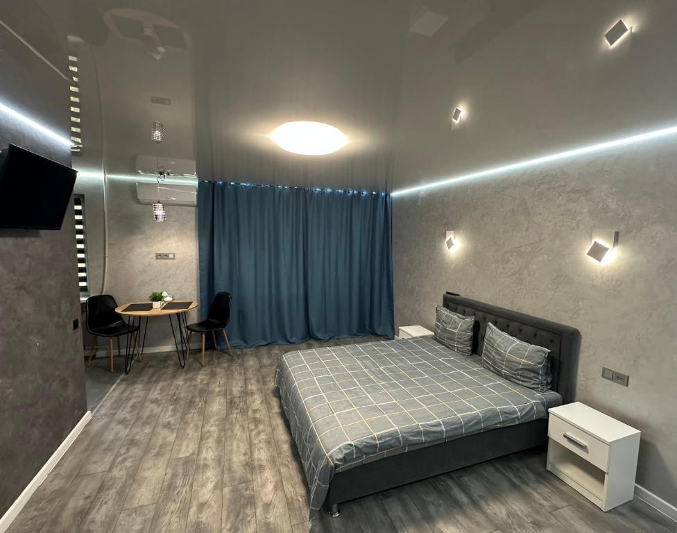 ApartCenter Студия VIP в центре города Гагарина في كريفوي روغ: غرفة نوم بها سرير وطاولة وكراسي