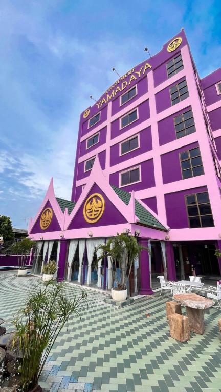 a purple building with a table in front of it at Yamadaya Apartment in Phra Nakhon Si Ayutthaya
