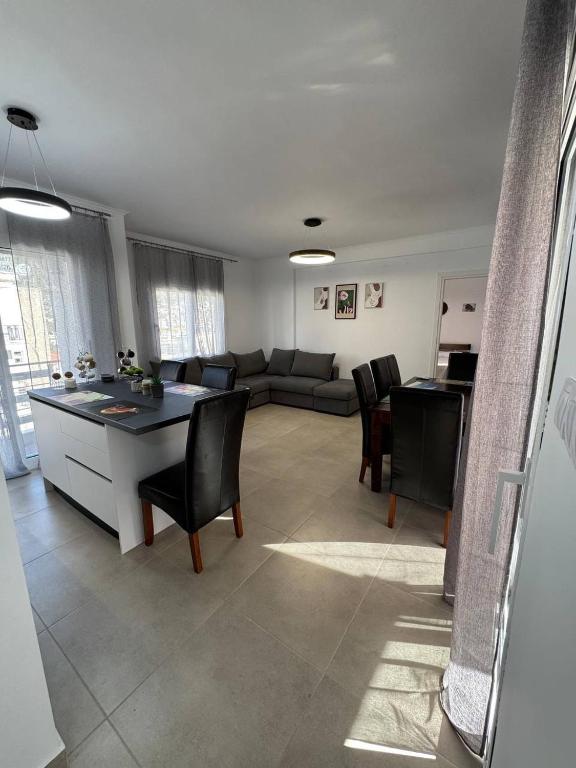 a living room with a couch and a table and chairs at Panorama Apartment in Kavála