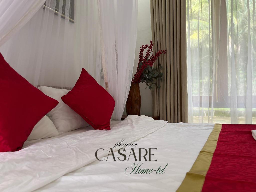 a bedroom with a bed with red and white pillows at Casare Phu Quoc - Formerly Caesar Hotel in Phu Quoc