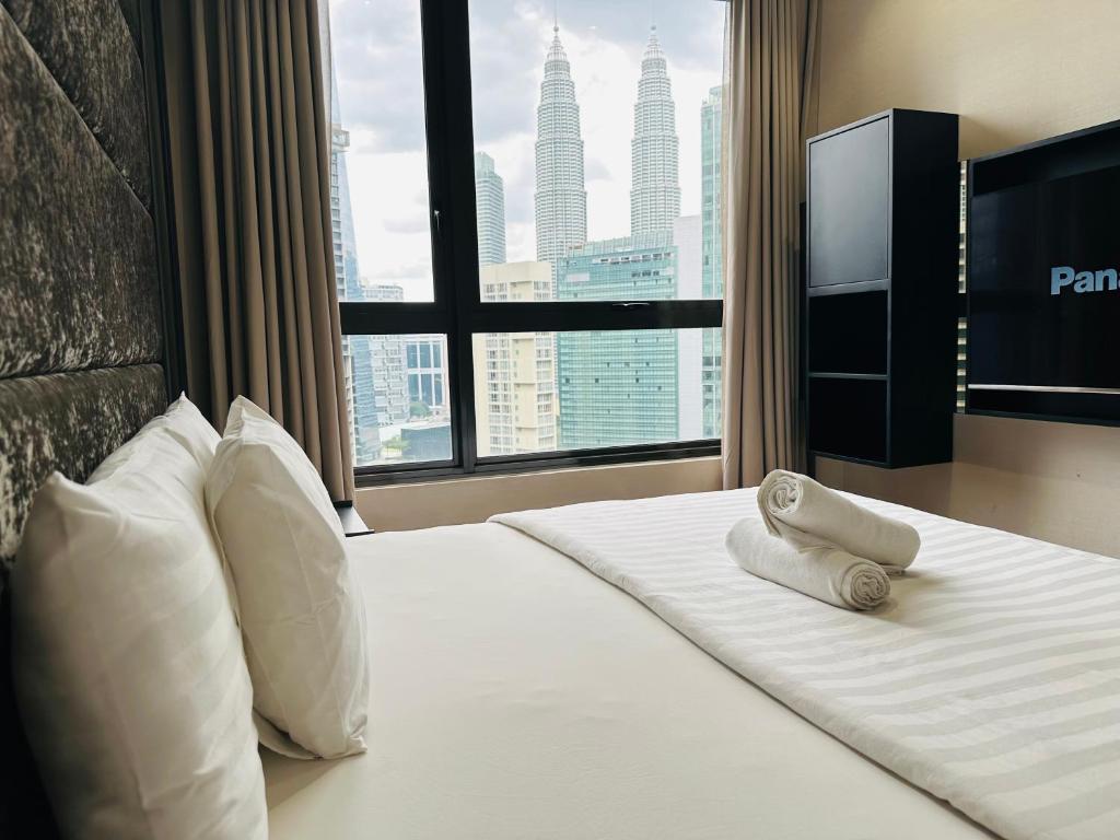 a hotel room with a bed with a view of a city at KLcc suites astra 8 kia peng in Kuala Lumpur