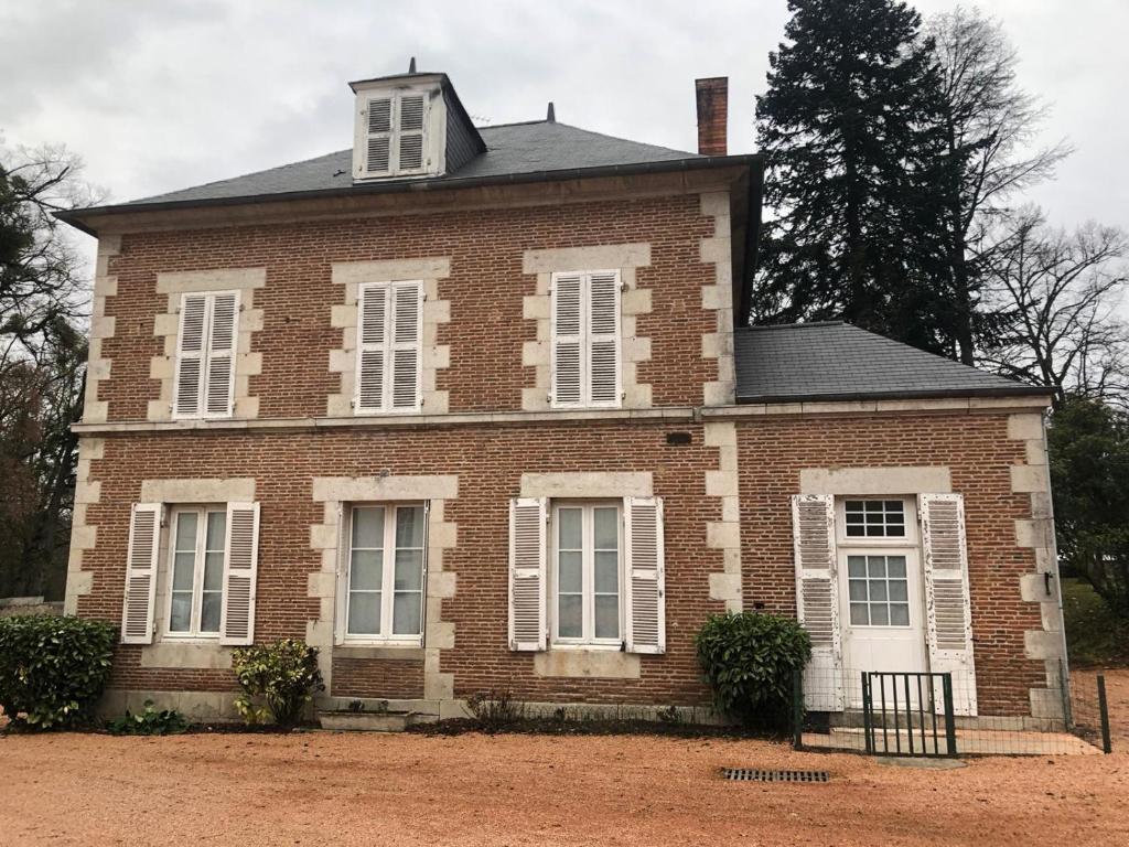 an old brick house with white windows and a tree at 2 bedroom Gîte-Cottage- Chateau de Charmeil in Charmeil