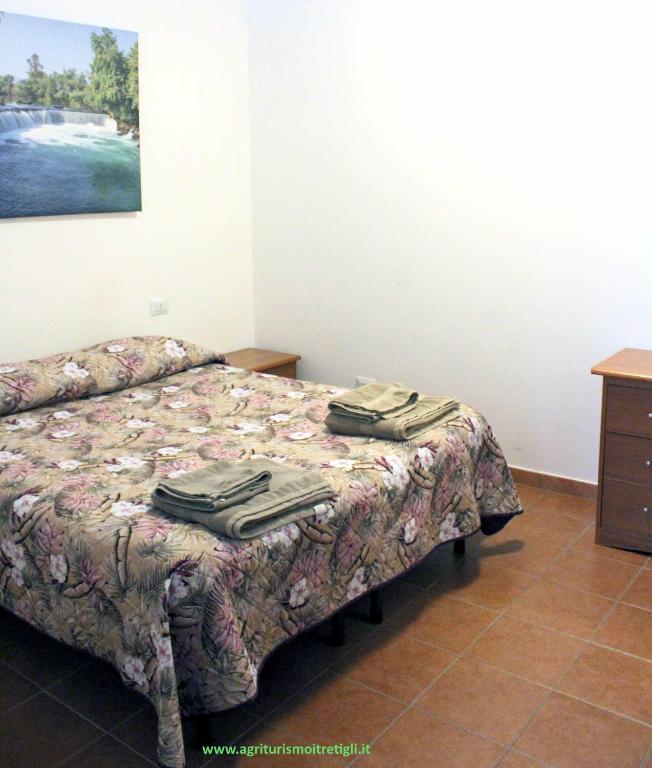 a bedroom with a bed with clothes on it at Agrimar 2 in Rignano Flaminio