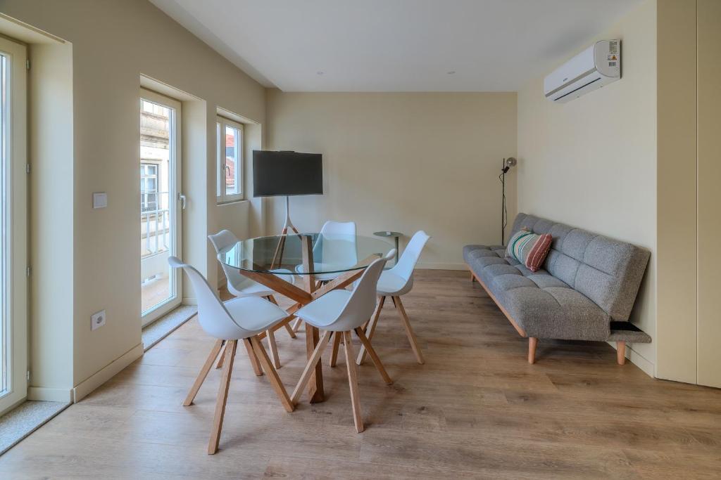 a living room with a table and chairs and a couch at Urban Tales Barcelos in Barcelos