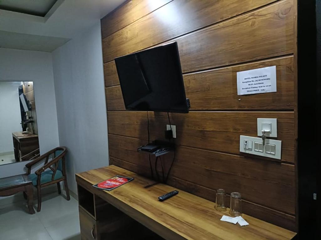 a wooden wall with a television on top of a desk at Hotel Sr Residency Jail Road Tilak Nagar in New Delhi