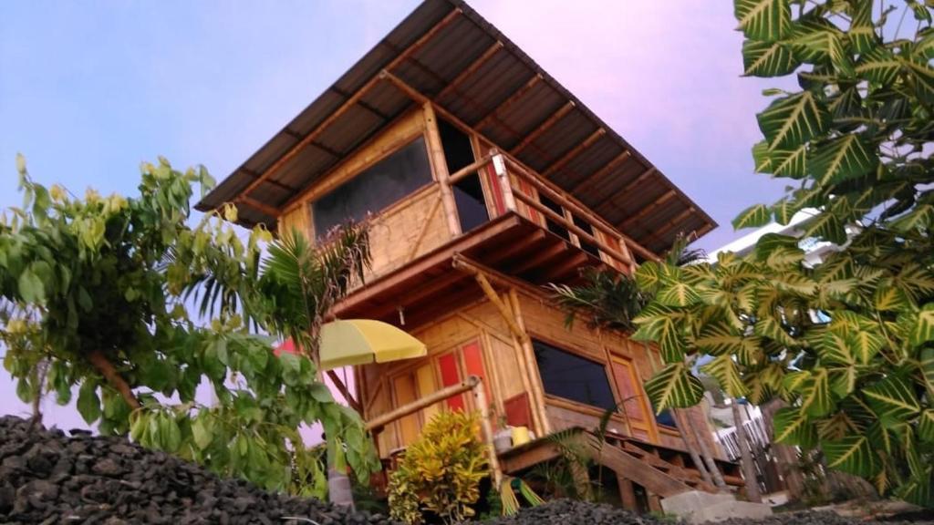 a house with a red door and some trees at Beach Cabin in Santa Marianita