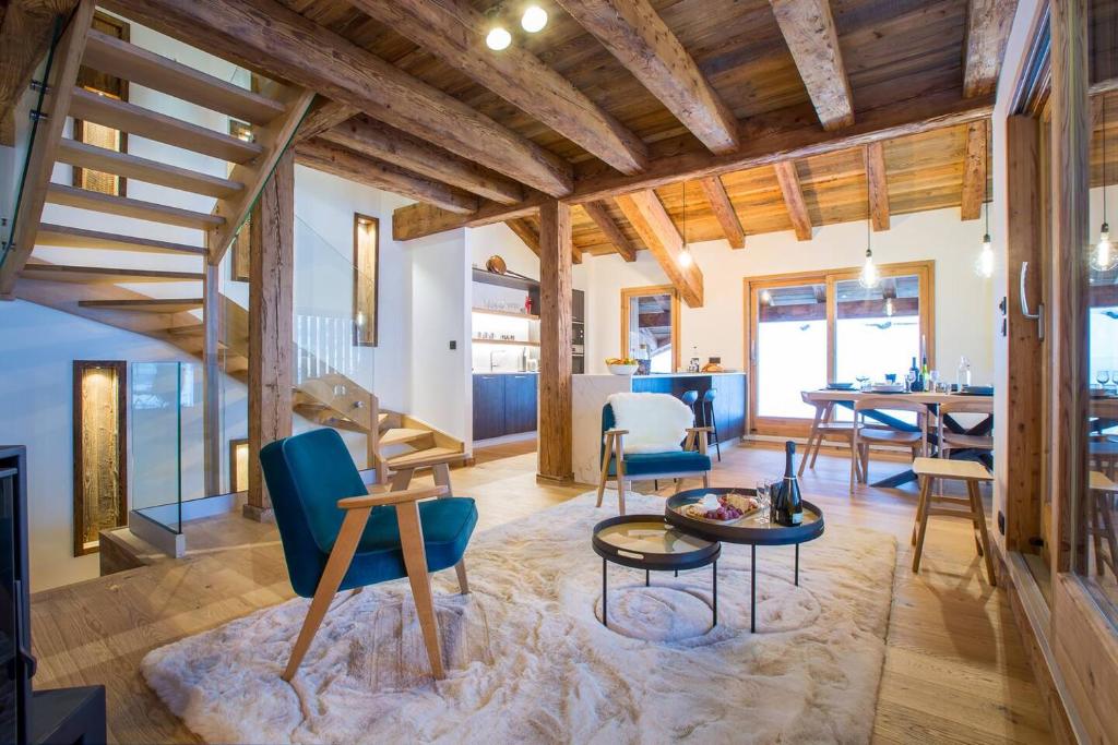 a living room with wooden ceilings and a table and chairs at More Mountain - La Ferme De Morzna In Morzine in Morzine