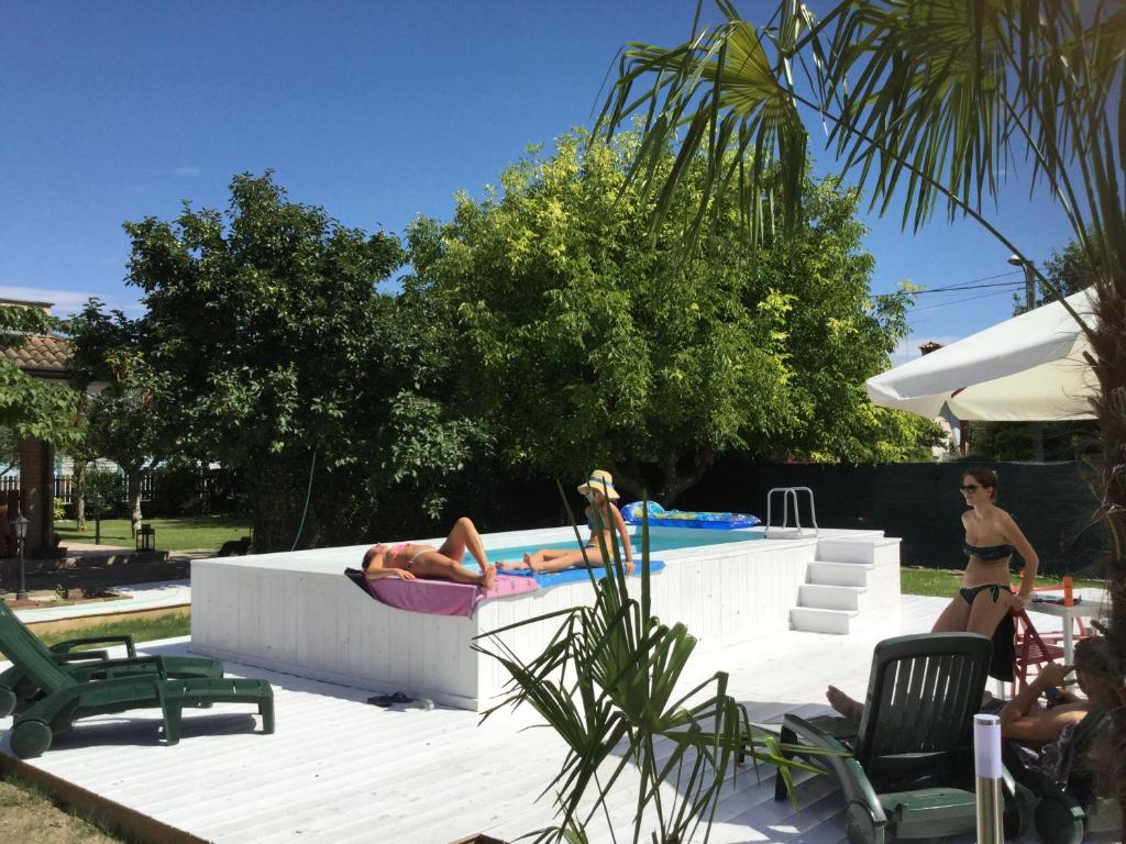 une femme posant dans une piscine avec une personne assise dans une chaise dans l'établissement B&B Isonzo, à Turriaco