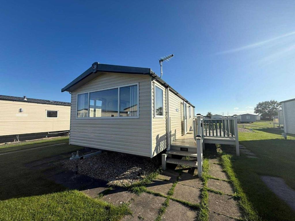 a tiny house with a bench in a yard at Salty Breezes in Ingoldmells