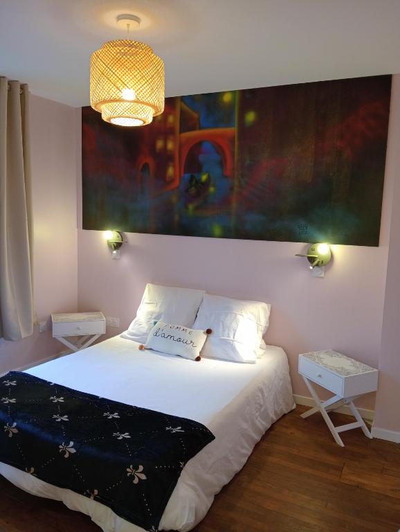 a bedroom with a bed and a painting on the wall at la pomme d'amour in Sully-sur-Loire