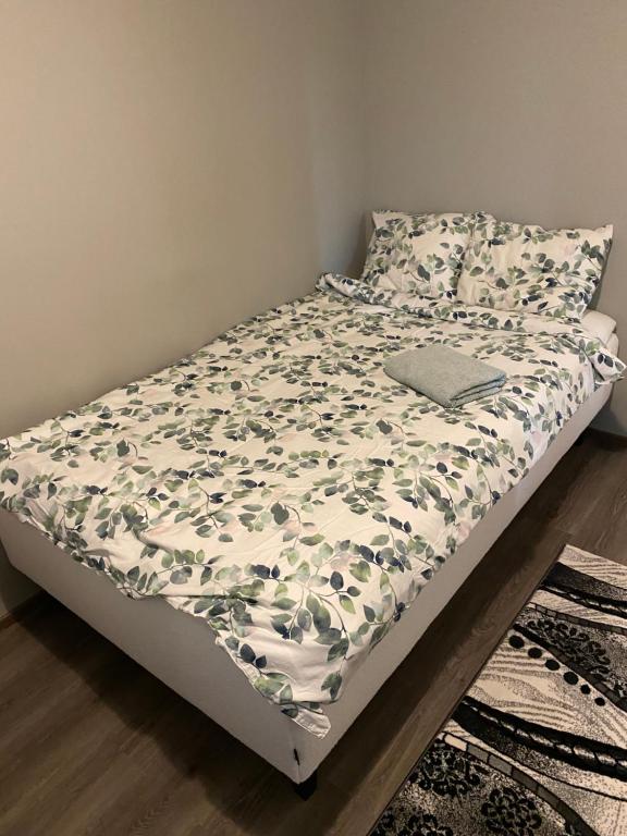 タンペレにあるMatilda Apartment with Peaceful environment and Barbecue facilitiesの花柄のベッドカバーが備わるベッドルームのベッド1台分です。