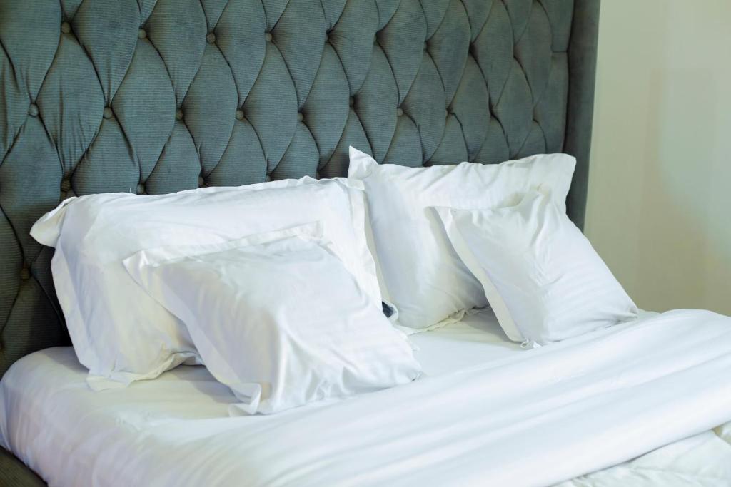 a bed with white pillows on top of it at Toria Homes in Namulanda